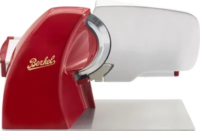 A red and silver electric slicer on a reflective surface against a white background.