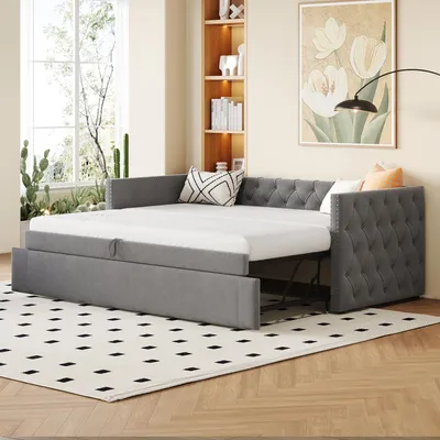 A gray sofa bed is shown in a room with a window and a bookshelf.