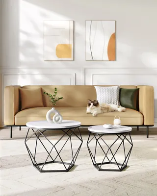 A living room scene with a sofa, coffee tables, and artwork.