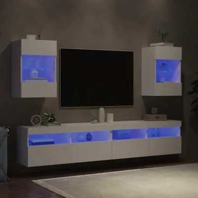 A modern living room setup with a wall-mounted TV and media console, illuminated by blue LED lights.