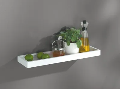 A white shelf mounted on a gray wall, displaying kitchen items.