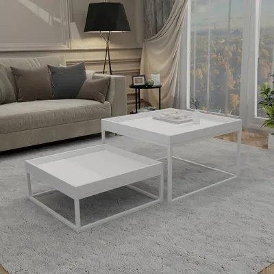 A living room scene with a sofa, floor lamp, and two white coffee tables.