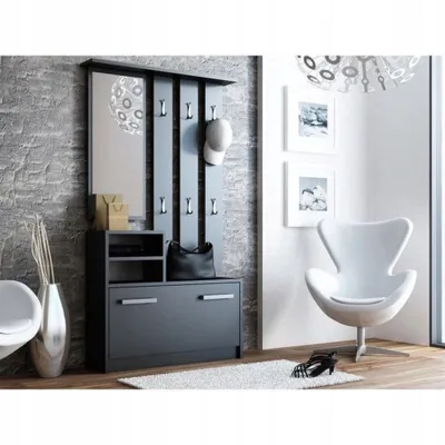 A modern entryway with a dark gray coat rack and shoe cabinet, a white armchair, and decorative items.