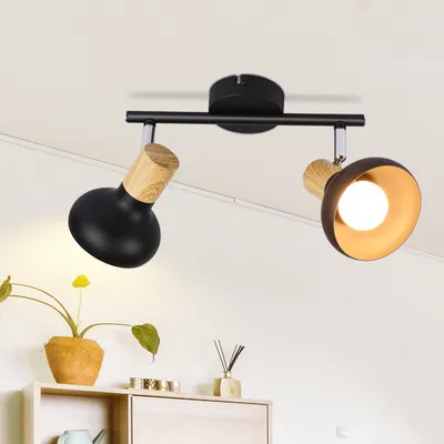 A black ceiling light fixture with two adjustable spotlights, each with a wooden accent, mounted on a white ceiling.