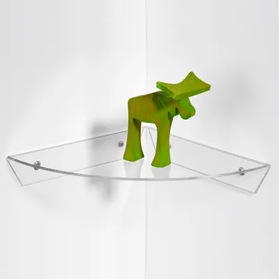 A green moose figurine sits on a transparent corner shelf mounted on a white wall.