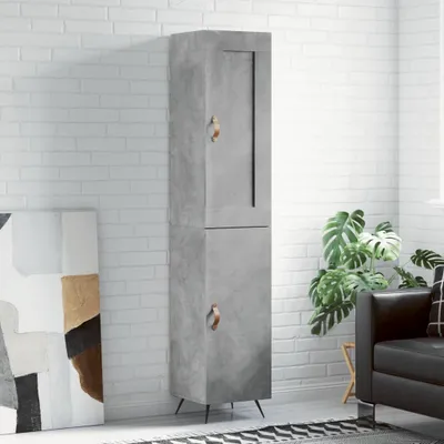 A tall, narrow concrete-look cabinet with two doors stands against a white brick wall. A large abstract painting is to the left, and a black leather sofa and a potted plant are to the right.