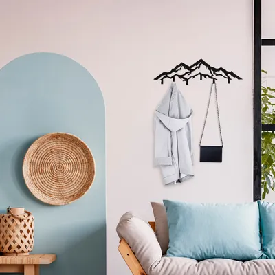 A minimalist living room with a mountain-shaped coat rack on the wall.