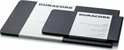 Two black cutting boards of different sizes are stacked on a white surface.