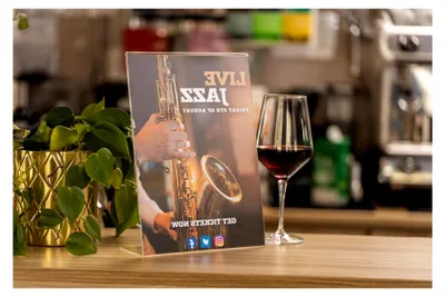Produktbild von Tischaufsteller A4 schräg mit Zusatzfach für Visitenkarten aus klarem Acryl