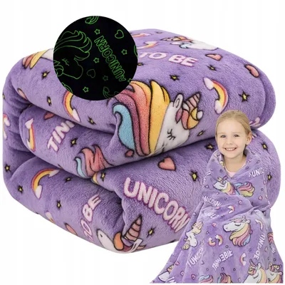 A folded purple blanket with a unicorn pattern is shown, with a young girl wrapped in a similar blanket next to it.