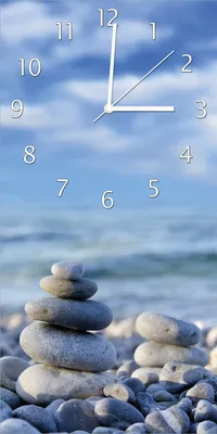 Produktbild von Wallario Design Wanduhr Steinstapel am Strand aus Echtglas, Größe 30 x 60 cm
