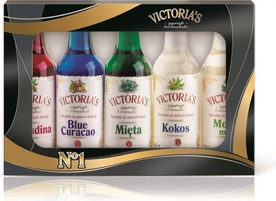 A gift set of five small bottles of flavored syrups in a black and gold box.