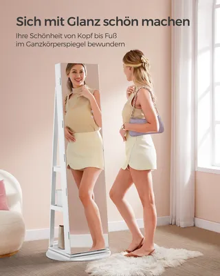 A woman is looking at herself in a full-length mirror, holding a handbag. The mirror is part of a jewelry cabinet.