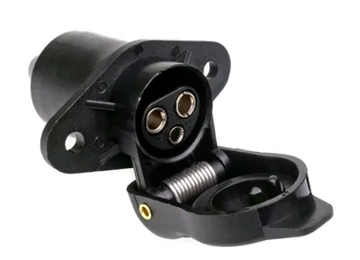 A black 3-pin trailer socket with its cover open, showing the connection points. The socket is mounted on a flange with screw holes.