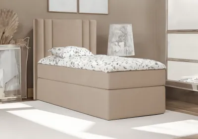 A bedroom scene with a single bed and bedding.