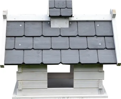 A close-up view of a wooden birdhouse with a gray shingled roof and white trim.