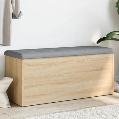A storage bench with a padded top is shown against a white wall.