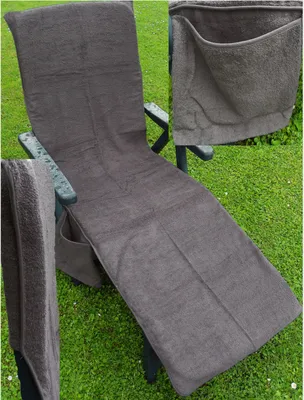A gray terrycloth chaise lounge cover with a side pocket is draped over a lounge chair on a grassy lawn.