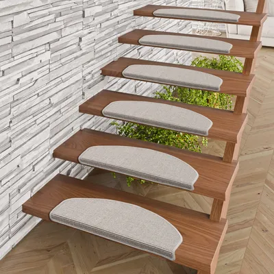 A set of stair mats on wooden stairs, with a stone-tiled wall in the background.