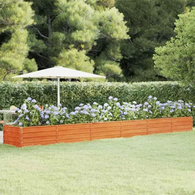 A wooden planter box filled with blue hydrangeas in a garden setting, with a large white umbrella in the background.