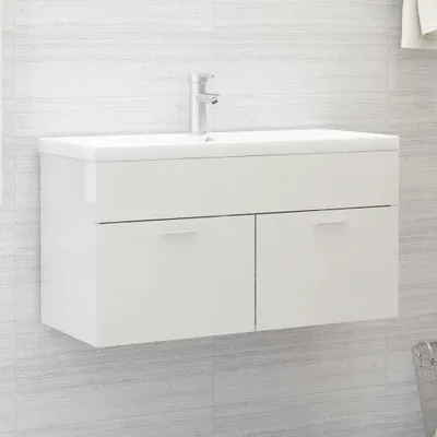 A white bathroom vanity with a sink and faucet mounted on a tiled wall.