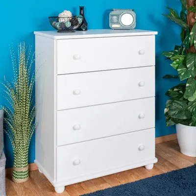 A white four-drawer dresser is shown against a bright blue wall, with decorative items on top and a plant to the side.