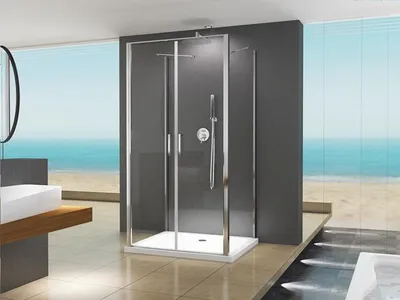 A modern bathroom with a shower cabin, sink, and a view of the ocean.