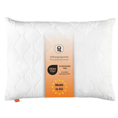 A white quilted pillow with a product tag attached.