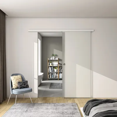 A modern bedroom with a sliding glass door leading to a bathroom.