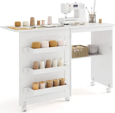 A white sewing table with a sewing machine and various spools of thread.