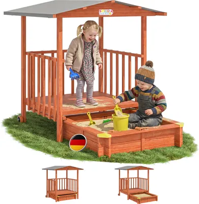Two children playing in a wooden sandbox with a covered veranda.