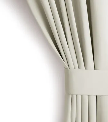 A close-up view of a cream-colored curtain with a tie-back.