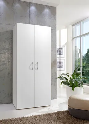A white two-door cabinet is shown in a well-lit room with a large window.