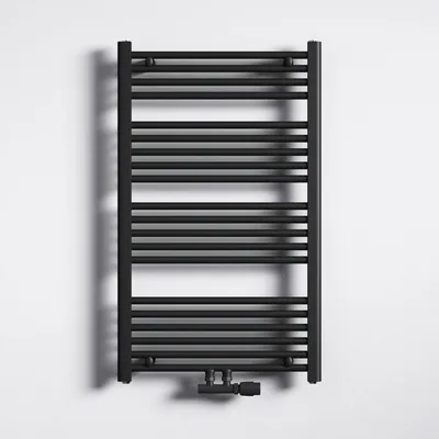 A black radiator is mounted on a white wall.
