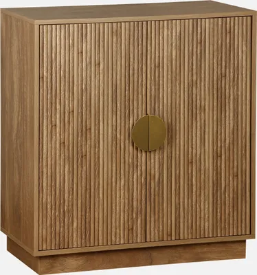 A wooden sideboard with two doors and a circular gold handle.