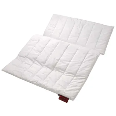 A white quilted comforter or duvet, folded in half and then folded again, lying on a white background.
