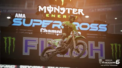 A motocross rider performing a jump during a Monster Energy Supercross event.
