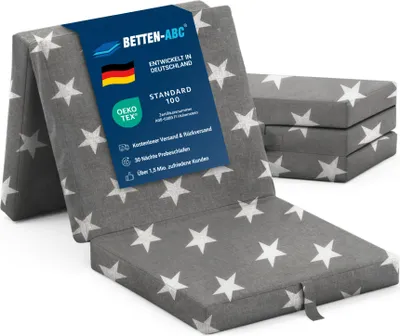 A folded mattress with a star pattern is shown, with a product information tag attached.