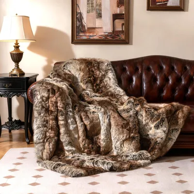 A plush faux fur blanket draped over a leather sofa in a living room setting.