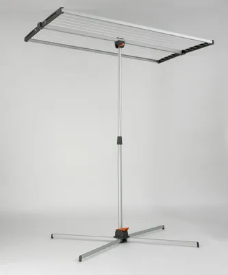 A freestanding clothes drying rack with a silver frame and black and orange accents, set against a plain light gray background.