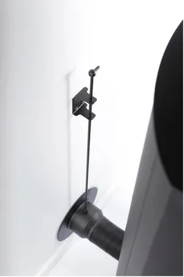 A close-up view of a ventilation system component attached to a white wall.