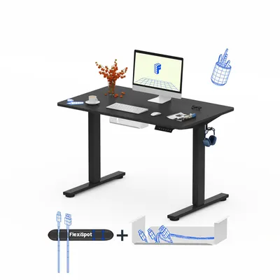 A black electric standing desk with a computer, keyboard, mouse, and a vase of flowers on top. Below the desk are accessories for cable management and a hook for headphones.