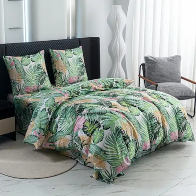 A bedroom scene with a bed dressed in tropical-themed bedding.