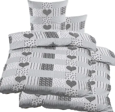 A stack of bedding with a patchwork design featuring hearts and stripes.