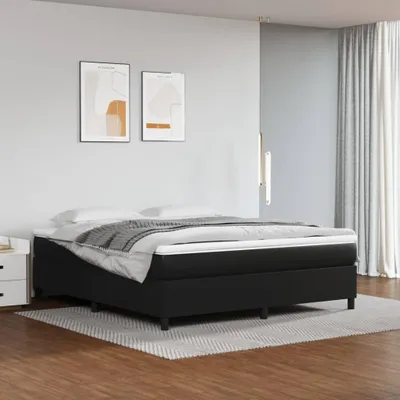 A bedroom scene with a bed, nightstand, and artwork on the wall.