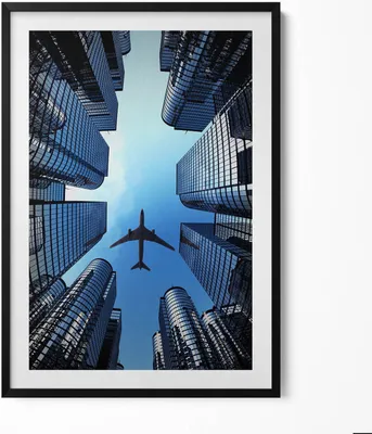 Produktbild von Flugzeug über Gebäuden– Wandbild mit Rahmen – Gerahmtes Bild  – Wanddekoration – 70x100 cm –  Schwarz Rahmen