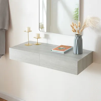 A floating shelf with decorative items on it, in front of a mirror.
