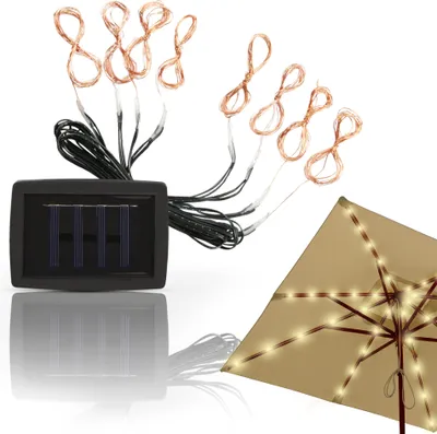 A solar-powered string light set with copper wire lights and a solar panel, shown next to a tan umbrella decorated with the lights.