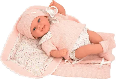 A baby doll lying on a pink blanket with a pacifier in its mouth.