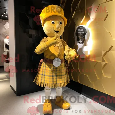 Productafbeelding van Gouden REDBROKOLY doedelzak mascottekostuum gekleed met een A-lijn jurk en schoenclips